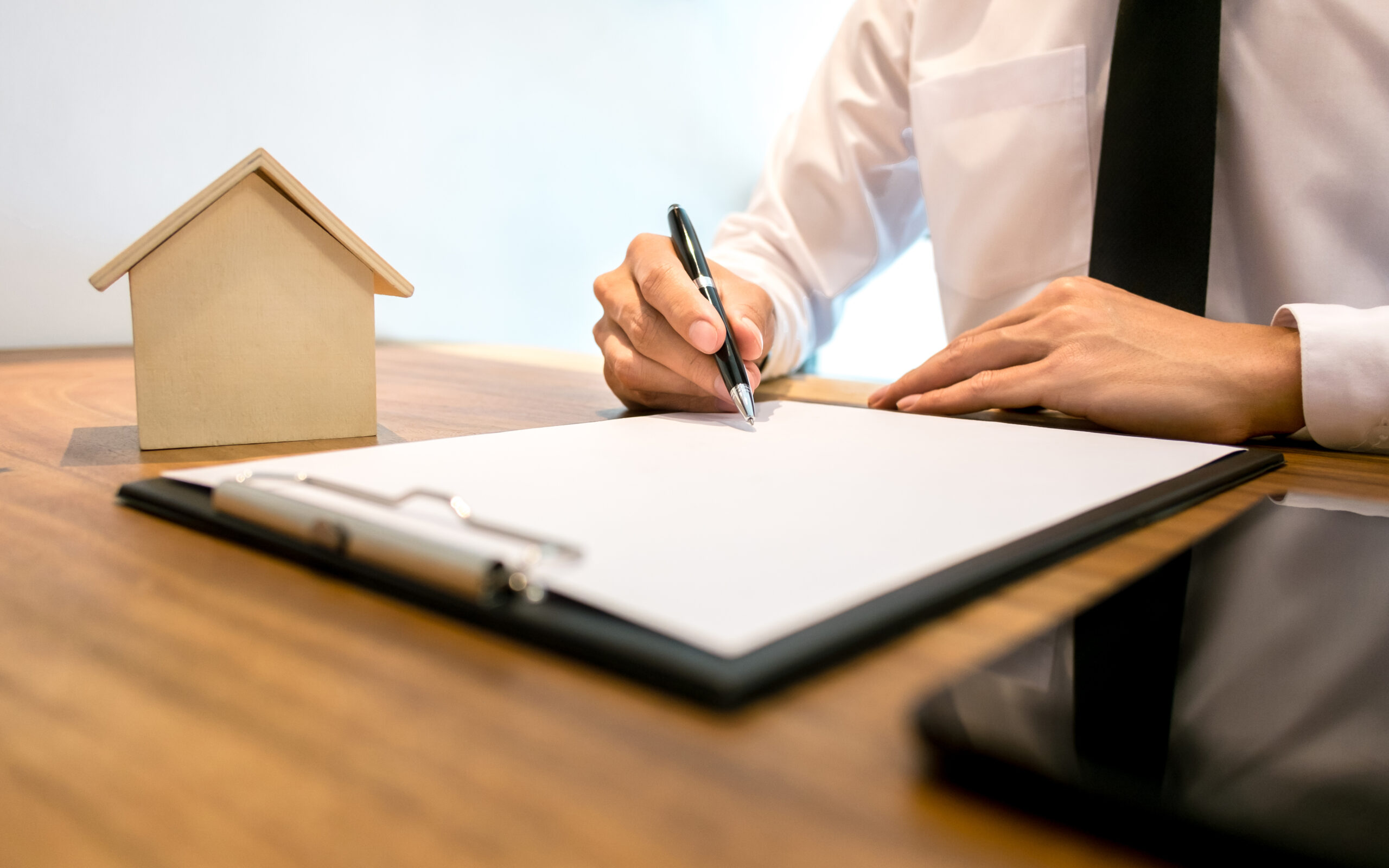 Real Estate agent with contract signature and analyzing valuation of house property